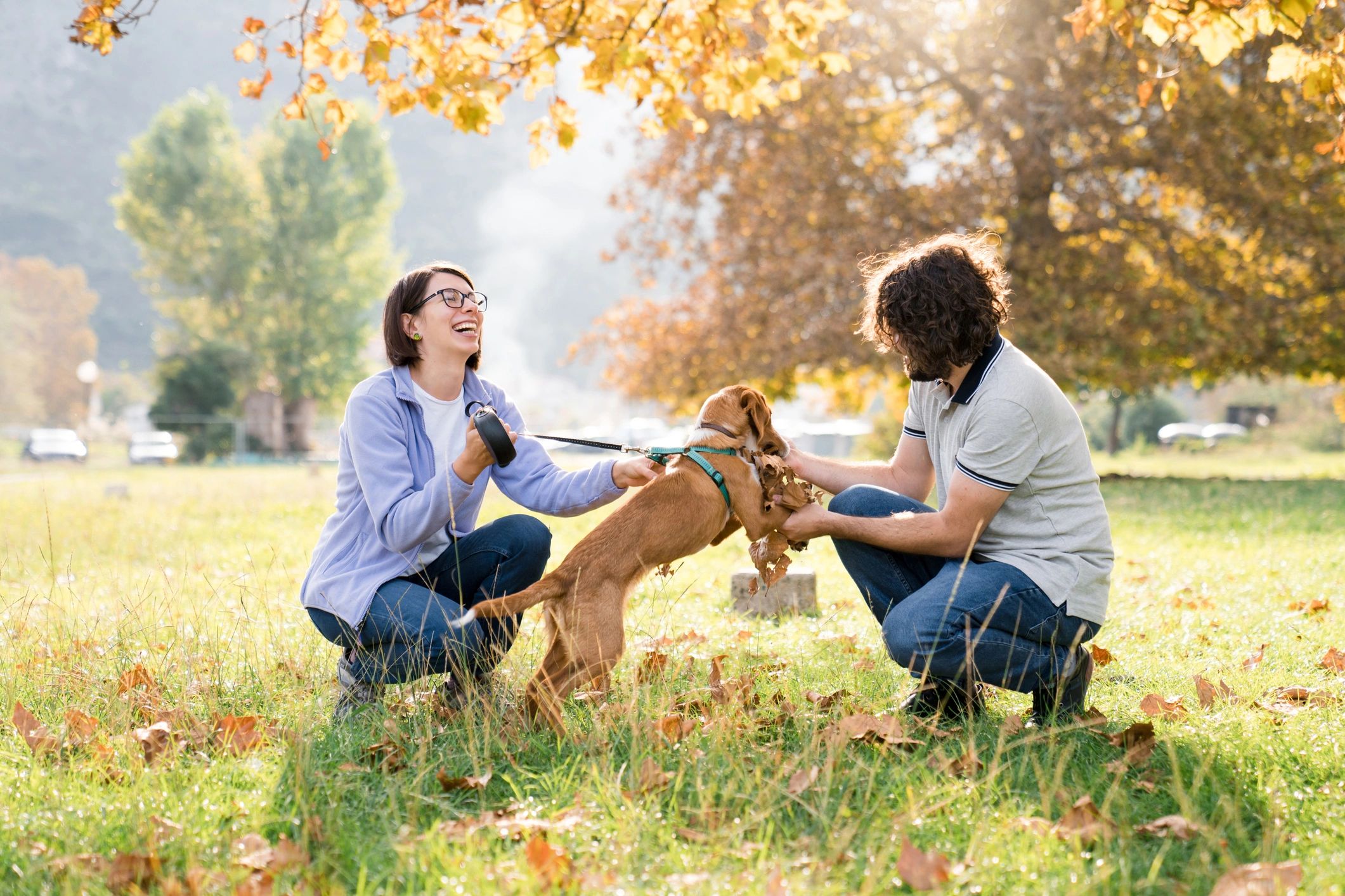 Couple playing with their puppy in a park